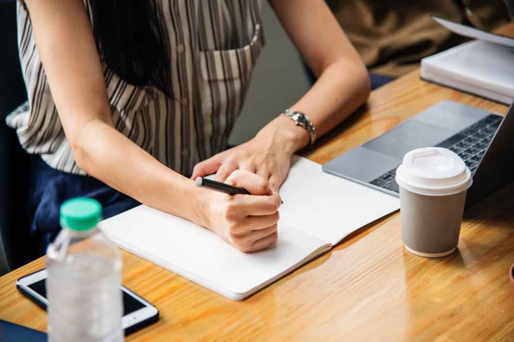 woman holding pen with white printer paper