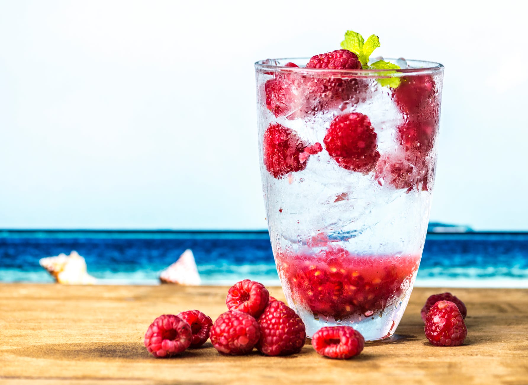 red raspberry in clear drinking glass