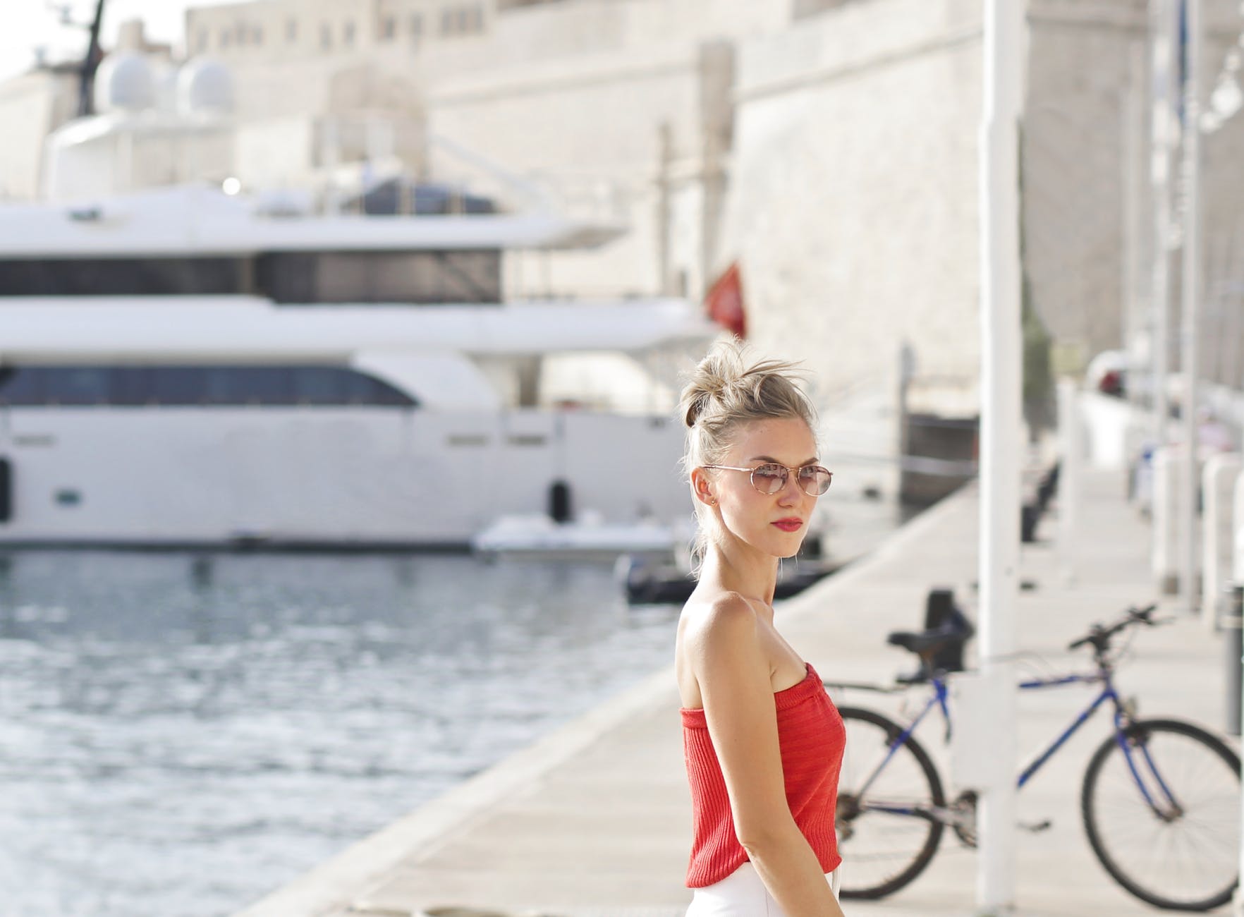 woman looking sideways beside white steel pole