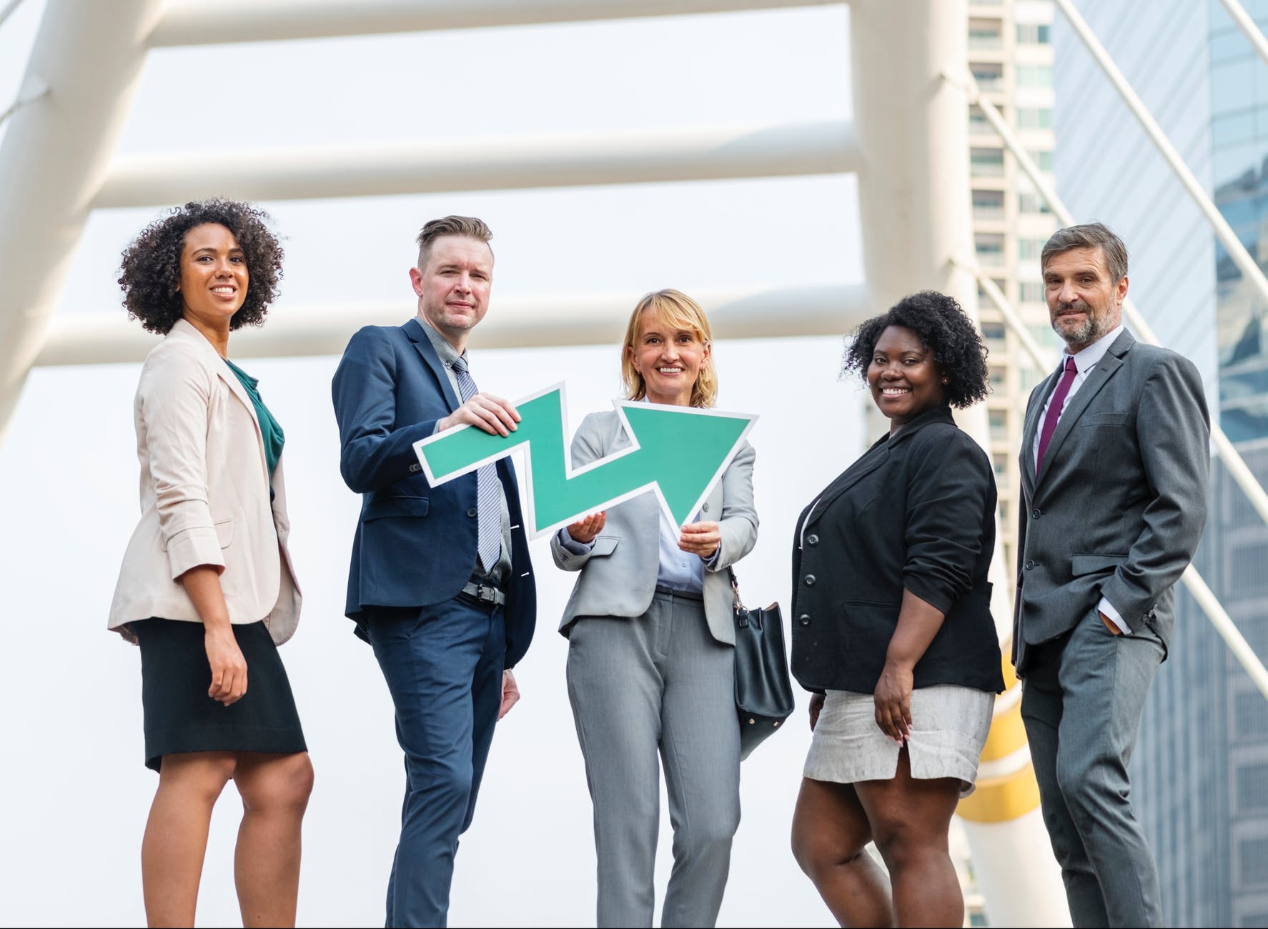 man holding zigzag arrow between four people